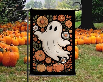 May include: A Halloween garden flag with a ghost design. The black flag is decorated with orange and white flowers, pumpkins, and a smiling ghost. The flag is displayed in a garden filled with pumpkins.