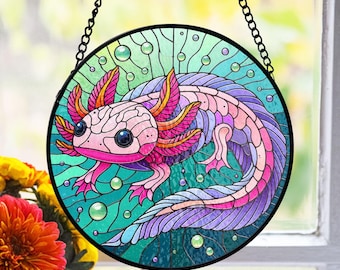 May include: A stained glass window hanging features a colorful axolotl with pink, purple, and blue hues. The axolotl is surrounded by a green, blue, and purple background with bubbles.