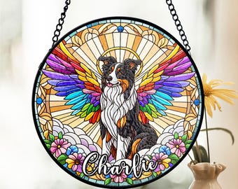 May include: A stained glass window memorial with a rainbow-colored angel wing design and a black and white border collie dog. The dog is wearing a halo and the name "Charlie" is written below the dog.