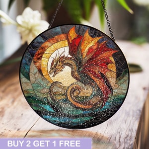May include: A stained glass window hanging with a circular frame depicting a red, orange, and yellow dragon with wings outstretched, emerging from a swirling blue and green water scene.