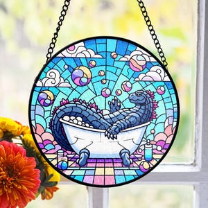 May include: A stained glass window hanging features a blue and purple dinosaur taking a bath in a white bathtub. The dinosaur is surrounded by colorful bubbles and clouds. The background is a rainbow of colors.