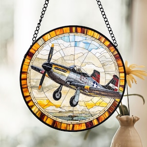 May include: A stained glass window hanging with a metal chain. The window features a colorful depiction of a vintage airplane with the number "8501" on the side.