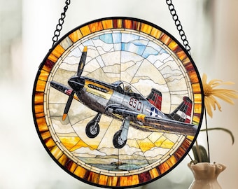 May include: A stained glass window hanging with a metal chain. The window features a colorful depiction of a vintage airplane with the number "8501" on the side.