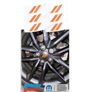 May include: A set of orange reflective wheel decals with the Mopar logo. The decals are on a white background and are designed to be placed on the wheel of a car. The decals are officially licensed by Mopar.