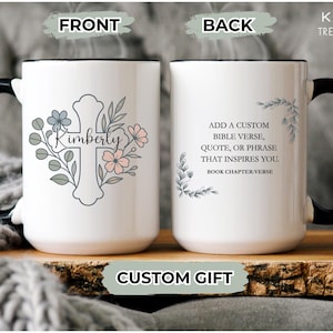 May include: White ceramic mug with a black handle and rim. The front features a cross design with the name "Kimberly" and floral accents. The back has text that reads "Add a custom Bible verse, quote, or phrase that inspires you."