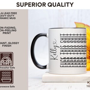 May include: White ceramic mug with a black rim and handle. The mug has a black design of various stitches and the name "Kellye" written on the side. The mug is sitting on a white coaster. The background is a blurry image of a yellow sunflower.