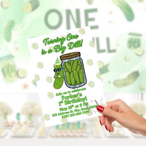 Puede incluir: Una invitaci&oacute;n de cumplea&ntilde;os con un pepinillo de dibujos animados con gafas de sol y un gorro de fiesta, con un tarro de pepinillos. El texto dice "Turning One is a Big Dill!" e incluye detalles de la fiesta.