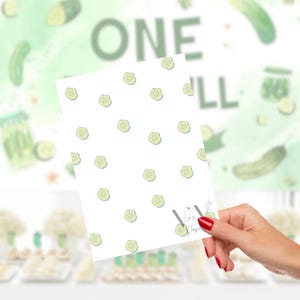Puede incluir: Una tarjeta blanca con un patr&oacute;n de rodajas de pepinillos verde claro se sostiene en una mano con esmalte de u&ntilde;as rojo. El fondo presenta las palabras "ONE PILL" y un dise&ntilde;o de acuarela de pepinillos y tarros.