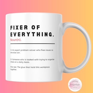May include: White ceramic mug with a black and white design that reads "FIXER OF EVERYTHING. Noun(n). 1)-An expert problem solver who fixes issues no one else can. 2)-Someone who is tasked with trying to organize chaos on a daily basis. Also see: The glue that hold this workplace together."