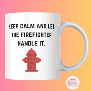 Könnte beinhalten: Weiße Keramiktasse mit schwarzem Text, der "Keep Calm and Let the Firefighter Handle It." lautet. Unter dem Text befindet sich eine rote Feuerwehrhydranten-Illustration.