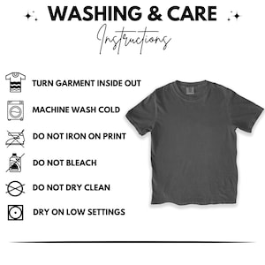 May include: A dark gray t-shirt with washing instructions. The instructions include turning the garment inside out, machine washing cold, not ironing on print, not bleaching, not dry cleaning, and drying on low settings.