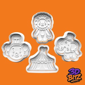 May include: Four white plastic cookie cutters in the shapes of circus characters. The shapes include a clown, a lion, a circus tent, and an elephant wearing a top hat. The background is orange, and the logo "3D BITZ" is in the bottom right corner.