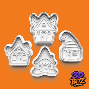 May include: Four white plastic house-shaped cookie cutters. Each cutter has a unique design, including a house with wings, a house with a flower, a house with a pointed roof, and a house with a rounded roof. The background is orange.
