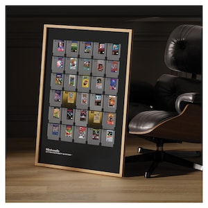 May include: A framed print featuring a collection of Nintendo Entertainment System game cartridges. The cartridges are arranged in a grid on a black background, with the words "Nintendo Entertainment System" at the bottom. The frame is light brown.