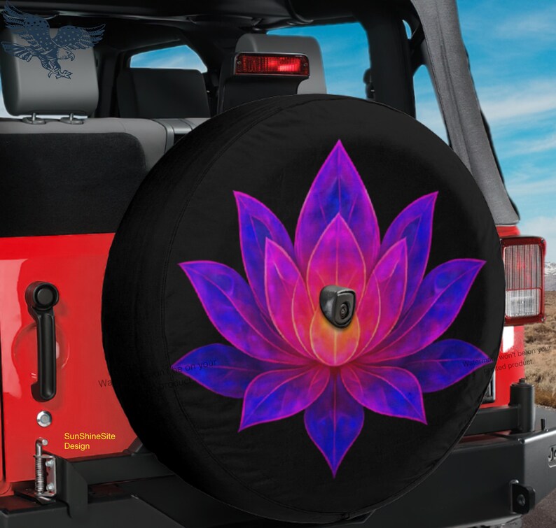 May include: Black spare tire cover featuring a vibrant, stylized lotus flower design. The flower has purple and pink petals with a yellow center. The cover is mounted on a red Jeep.