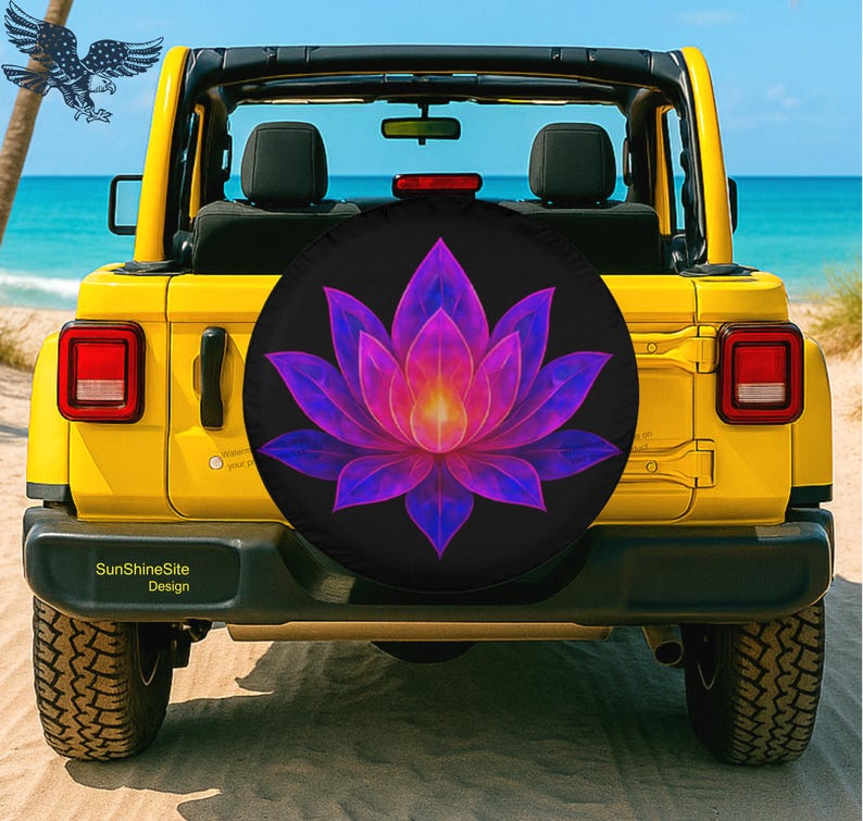 May include: A yellow Jeep with a black spare tire cover featuring a vibrant lotus flower design in shades of purple, pink, and yellow. The background shows a beach and ocean.