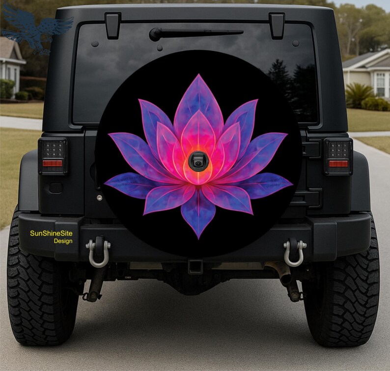 May include: Black spare tire cover featuring a vibrant, stylized lotus flower design. The flower has pink and purple petals with a bright center. The cover is mounted on a black Jeep. The text "SunshineSite Design" is visible.