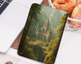 May include: A tablet case featuring a detailed illustration of a castle nestled in a lush green forest. The artwork depicts a towering structure with multiple spires, surrounded by trees and a waterfall. The case has a dark border.