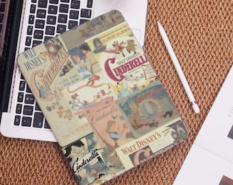 May include: A rectangular tablet case featuring a collage of vintage "Cinderella" movie posters. The case is on a laptop keyboard, with a white stylus and a drink nearby. The case has a beige background with colorful illustrations and text.