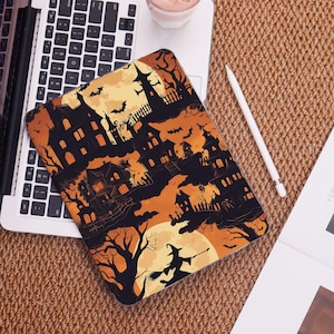 May include: A rectangular tablet case featuring a repeating Halloween-themed pattern with black silhouettes of haunted houses, bare trees, flying bats, and a witch on a broomstick against a vibrant orange and yellow gradient background.