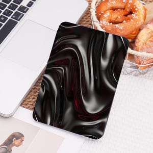 May include: A black and red abstract design with a glossy, liquid-like texture. The design is reminiscent of flowing fabric or a swirling liquid.