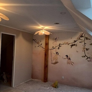 May include: A room with a whimsical fairy theme. Two flower-shaped ceiling lights illuminate the space. The walls feature a mural of fairies and floral vines. A door and a slanted window are also visible.