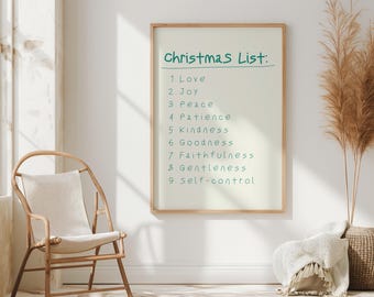Puede incluir: Un póster enmarcado blanco con el texto "Christmas List:" y una lista de nueve virtudes escritas en verde. El póster está colgado en una pared blanca con una silla de mimbre y una planta de hierba seca en una cesta tejida.