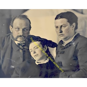 May include: A vintage black and white photograph featuring three individuals. A man with a mustache and bow tie stands on the left, a woman stands on the right, and a person wearing a pearl necklace is positioned in the center. Text reads: This text is not on this photo picture print.