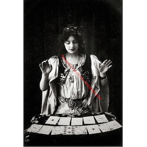 May include: Vintage black and white photograph of a woman dressed as a fortune teller. She is surrounded by tarot cards, with her hands raised. The woman is wearing a decorative top and headpiece.