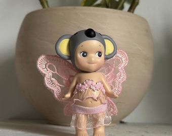 Roupa de anjo Sonny - Detalhes florais rosa bebê com grandes asas rosa.
