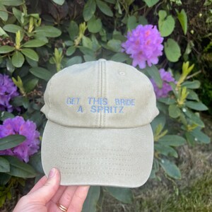Bride accessories hat with custom aperol style embroidery, fun hen party outfit idea and bridal shower present