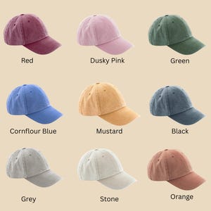 May include: A collection of nine baseball caps in various colors, including red, dusky pink, green, cornflower blue, mustard, black, grey, stone, and orange. The caps are arranged in a grid, with each color labeled below. The text "Vintage Colours" is at the top.