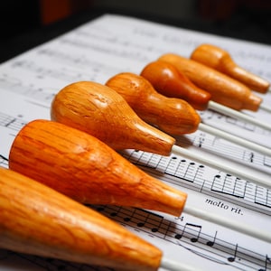 May include: A set of three ceramic mugs with a speckled, matte finish. The mugs are in shades of cream, light gray, and dark gray. Each mug has a simple, minimalist design and a rounded handle.