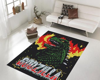 May include: A black and green rug with a pixelated image of Godzilla breathing fire. The text "Godzilla" is written in red and yellow pixels.