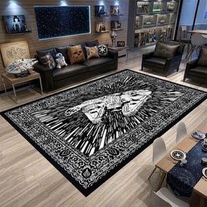 May include: Black and white Star Wars themed area rug featuring the Millennium Falcon in a speed effect design. The rug has a detailed border and is placed in a living room setting with Star Wars decor.