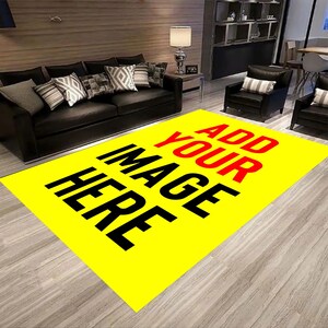 May include: A large, rectangular yellow rug with the text "ADD YOUR IMAGE HERE" in black and red. The rug is in a living room setting with a black sofa, armchairs, and decorative pillows. The rug is placed on a light-colored wooden floor.