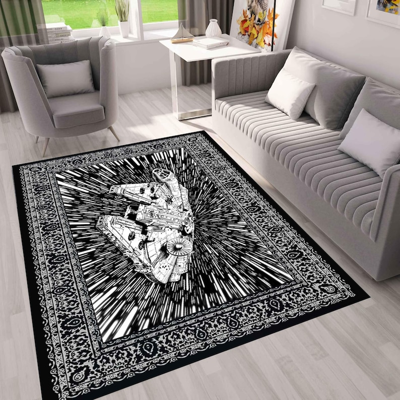 May include: Black and white area rug featuring a detailed illustration of a spaceship in a burst of speed lines. The rug has a decorative border and is placed in a living room setting.