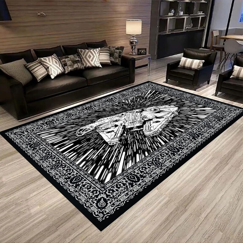 May include: Black and white area rug featuring a spaceship design with a starburst effect. The rug has a decorative border and is placed in a living room setting with black furniture.