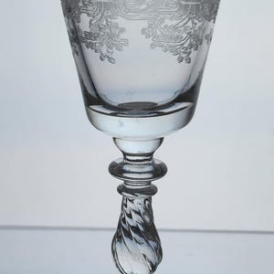 May include: A clear glass goblet with a twisted stem and a floral design etched around the top.