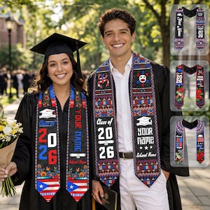 以下が含まれることがあります： 卒業ガウンと卒業ストールを着た2人の卒業生。ストールは黒で、カラフルなデザイン、「Class of 2026」の文字、名前と学校名を入れるスペースがあります。卒業生の一人は花のブーケを持っています。