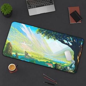 Puede incluir: Un tapete de ratón rectangular con un borde negro que representa un paisaje colorido con montañas, un río y un pequeño pueblo. Un ratón de computadora blanco está sentado en el tapete de ratón.