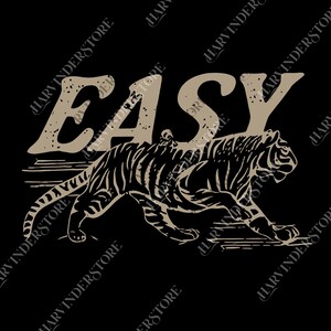 Op de afbeelding: Zwart grafisch T-shirt met het woord "EASY" in een verweerde bruine lettertype boven een gedetailleerde illustratie van een tijger. De tijger is bruin met zwarte strepen, op een zwarte achtergrond.