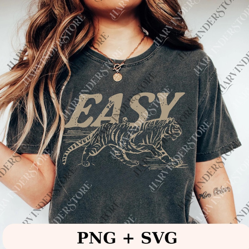Op de afbeelding: Donkergrijs t-shirt met het woord "EASY" in een verweerde lettertype boven een tijgerillustratie. De tijger is afgebeeld in een rennende pose, met een vintage esthetiek. Dit is een casual kledingstuk.