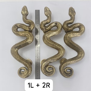 May include: Three brass-coloured snake-shaped door handles with textured scales. A metal ruler is placed between the handles, showing a length of approximately 41 cm. The handles are arranged in a row with the text 1L + 2R at the bottom.