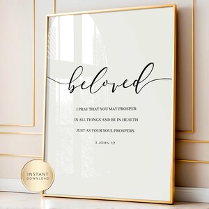 May include: A framed print with the word "beloved" in elegant script. Below, a quote from 3 John 1:2 is displayed in a clean, readable font. The print has a gold frame and a white background. A gold sticker says "INSTANT DOWNLOAD".