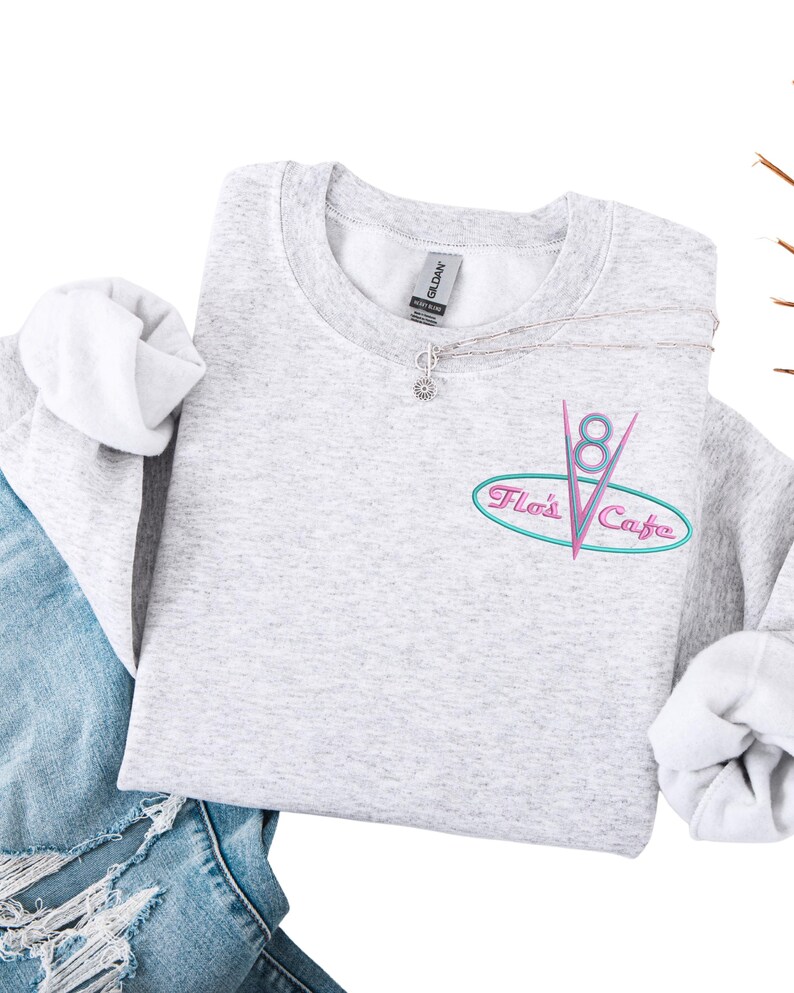 Puede incluir: Una taza de cer&aacute;mica blanca con asa negra y el texto "But First, Coffee" en negrita negra. La taza se destaca sobre un fondo borroso, resaltando su dise&ntilde;o limpio.