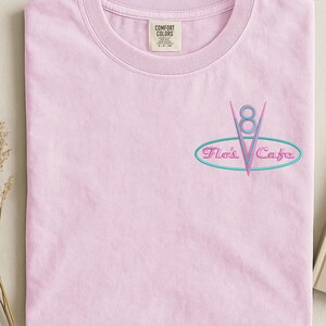 Puede incluir: Una taza de cer&aacute;mica blanca con un asa negra y el texto "But First, Coffee" en negro y negrita. La taza est&aacute; sobre una superficie blanca. La taza mide 10 cm de alto.