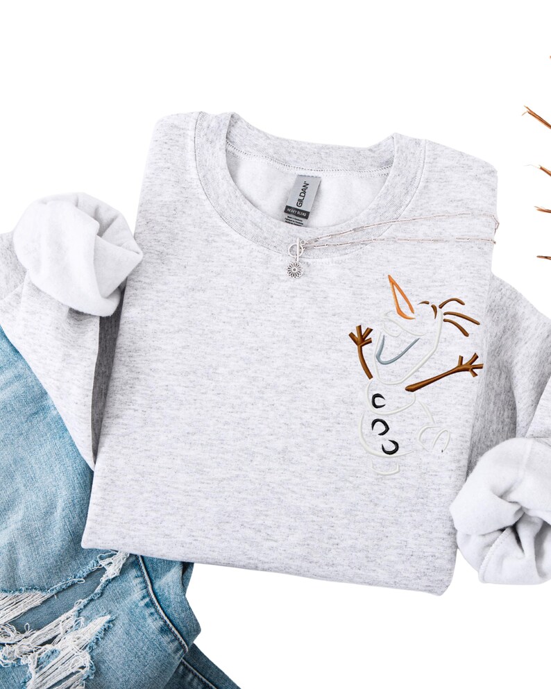 May include: A white ceramic mug with a black handle and the text "But First, Coffee" in a bold, black font. The mug is set against a blurred background. The mug is approximately 10 cm tall.