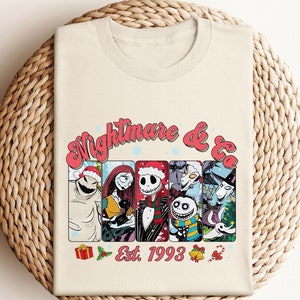 Puede incluir: Una camiseta blanca con un gr&aacute;fico colorido de personajes de la pel&iacute;cula Pesadilla antes de Navidad. El gr&aacute;fico incluye el texto "Nightmare & Co. Est. 1993".