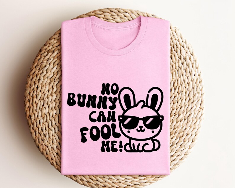 K&ouml;nnte beinhalten: Pinkes T-Shirt mit einer schwarzen Grafik eines Kaninchens mit Sonnenbrille und dem Text "No bunny can fool me!"